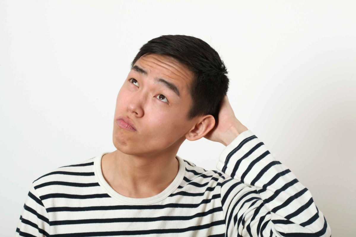 首をかしげる男性