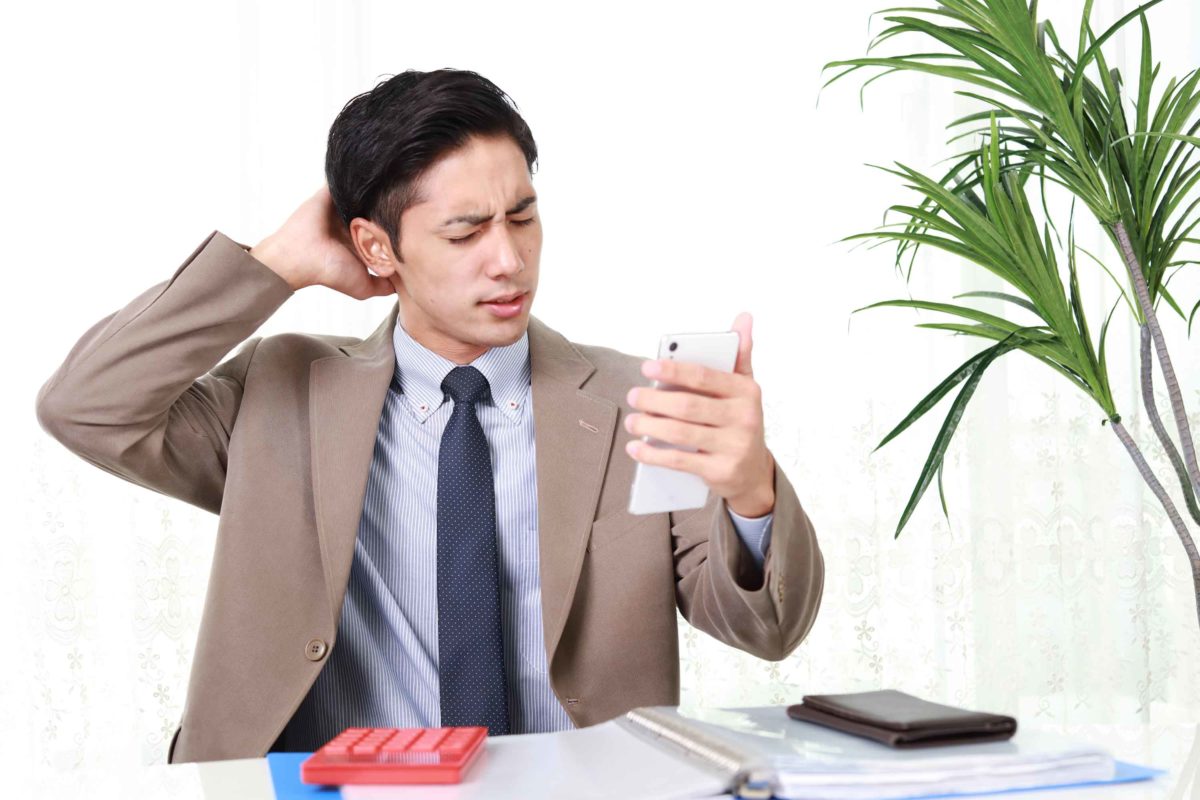 スマホを見て困る男性