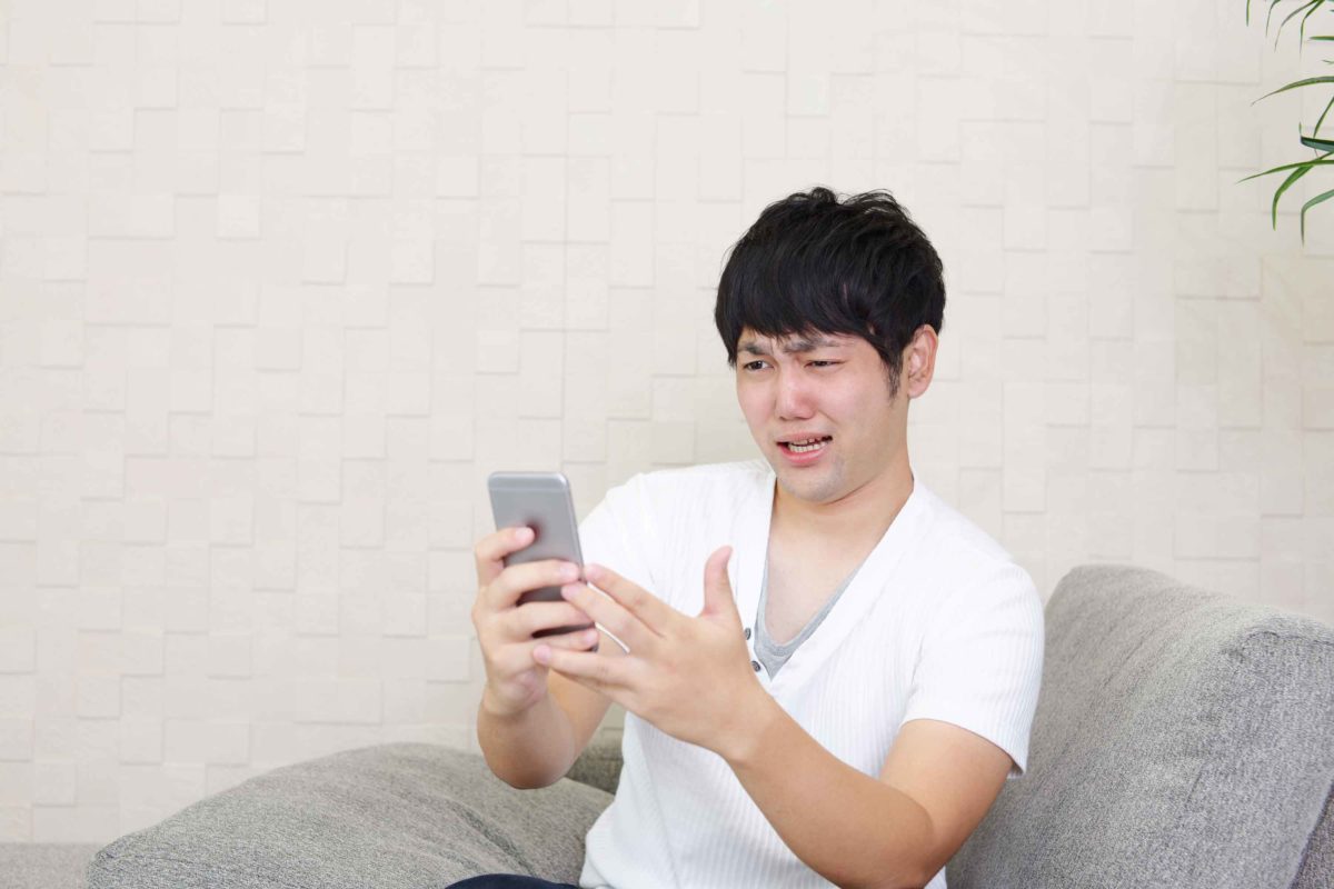 スマホを見て引く男性