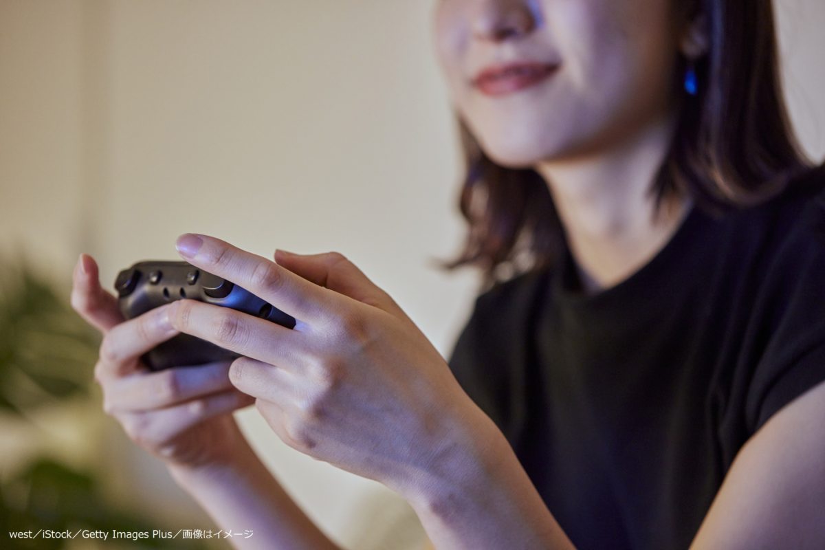 リビングでゲームをする若い日本人女性