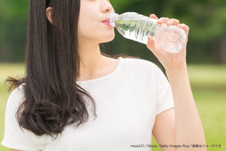 ペットボトルの水を飲む女性